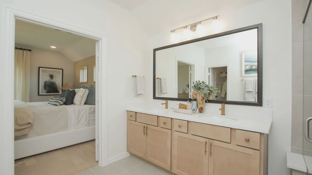 Experience refined living with a chic double vanity and gold-accented fixtures in Ellis Cove's luxurious bathroom. Experience refined living with a chic double vanity and gold-accented fixtures in Ellis Cove's luxurious bathroom.