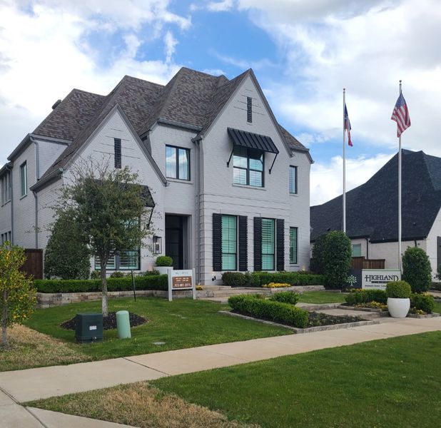 A stylish white brick home with lush landscaping in The Grove Frisco by Highland Homes (Frisco, TX). A stylish white brick home with lush landscaping in The Grove Frisco by Highland Homes (Frisco, TX).