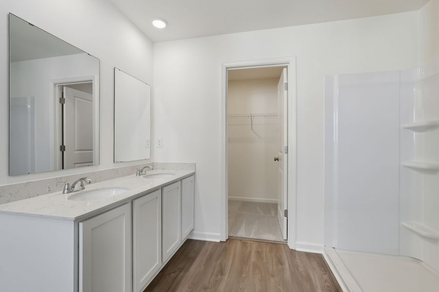 A bathroom with white cabinets.