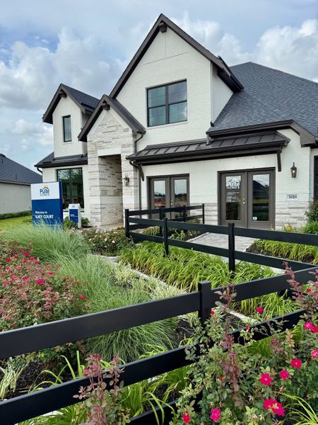 A charming two-story home with lush landscaping in Katy Court by Pulte Homes (Katy, TX).