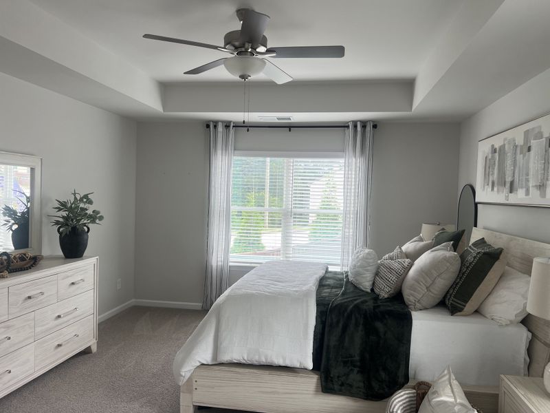 A cozy bedroom featuring a plush bed, elegant dresser, modern ceiling fan, and soothing neutral tones for a tranquil feel. A cozy bedroom featuring a plush bed, elegant dresser, modern ceiling fan, and soothing neutral tones for a tranquil feel.