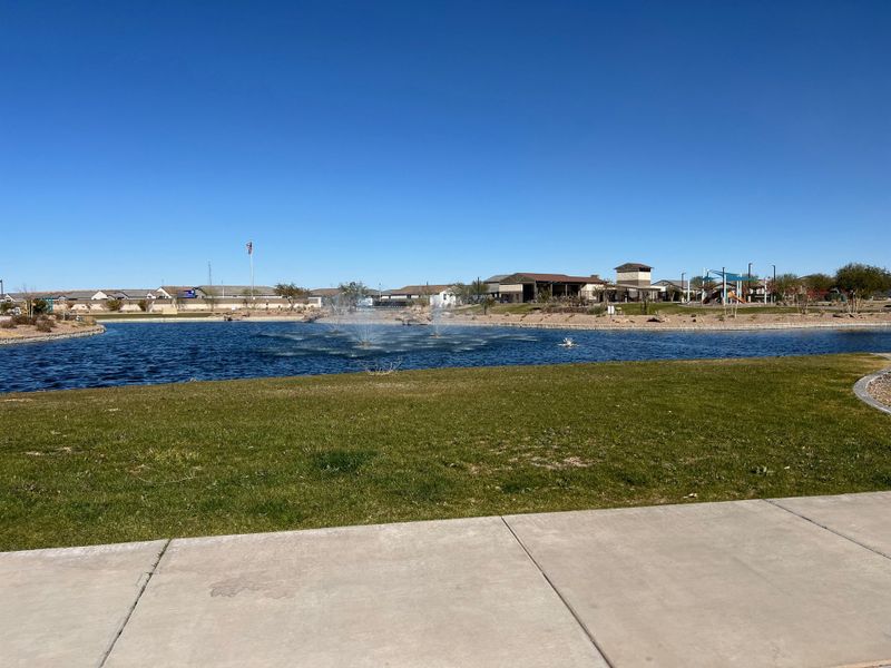 A picturesque lake with fountains in The Palms Collection at The Trails at Tortosa by Century Communities (Maricopa, AZ).
