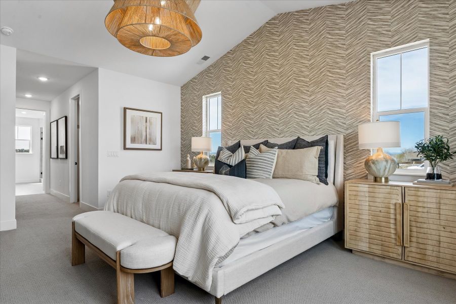 A bedroom with a bed and a bench.