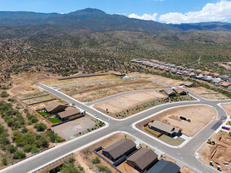 A large white building with a parking lot and trees in the background.