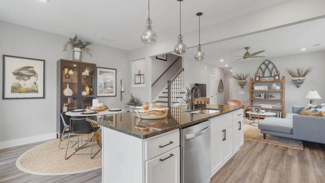 Black and white kitchen with modern accents and hardwood flooring at Barton Hollow by DRB Homes in Fountain Inn, SC