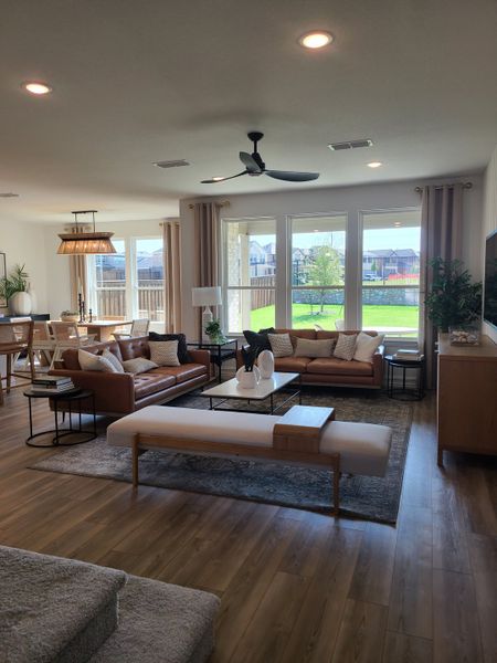 A spacious living room with elegant seating, natural light, and a view of the backyard through large windows. A spacious living room with elegant seating, natural light, and a view of the backyard through large windows.