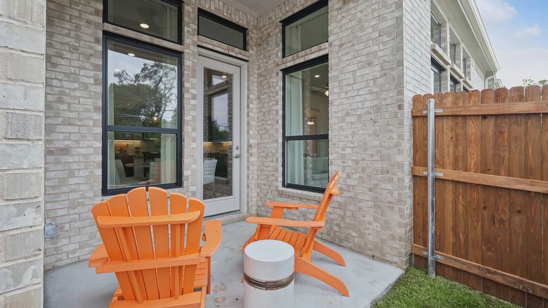 Heritage Park home's patio features elegant beige brick and sleek modern windows.