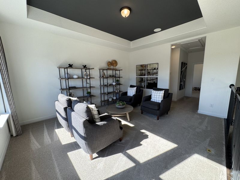 A cozy living area featuring gray seating, elegant open shelving, and ample natural light.
