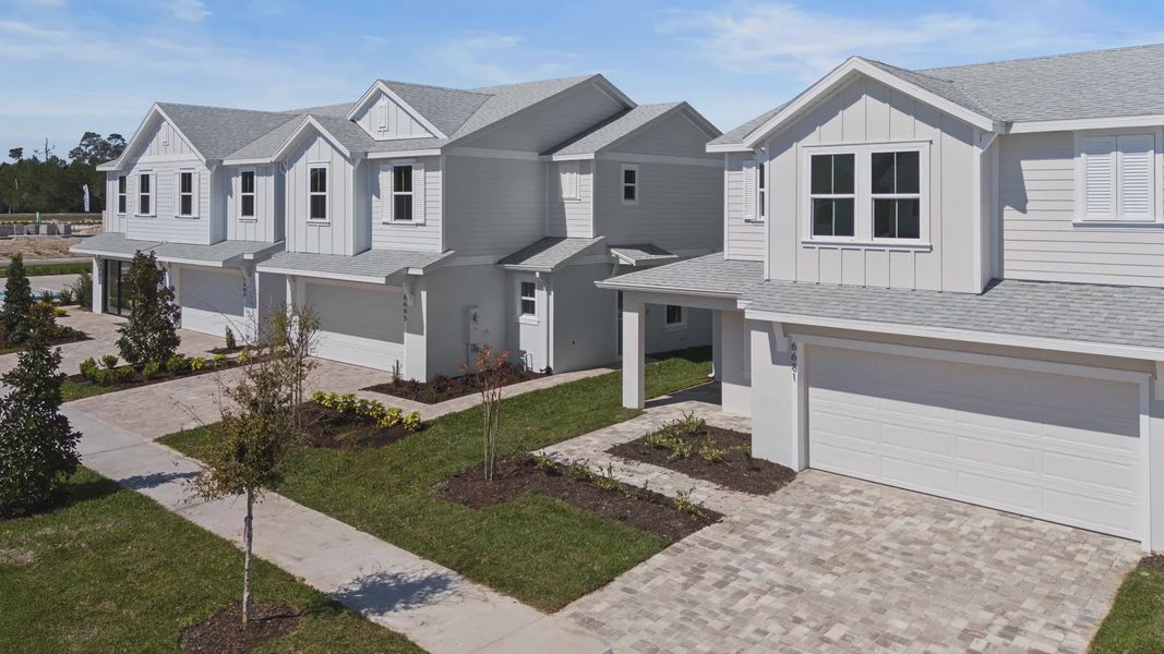 Cyrene at Harmony by DRB Homes features a paver driveway and walkway, enhanced by beautiful landscaping and serene lake views Cyrene at Harmony by DRB Homes features a paver driveway and walkway, enhanced by beautiful landscaping and serene lake views