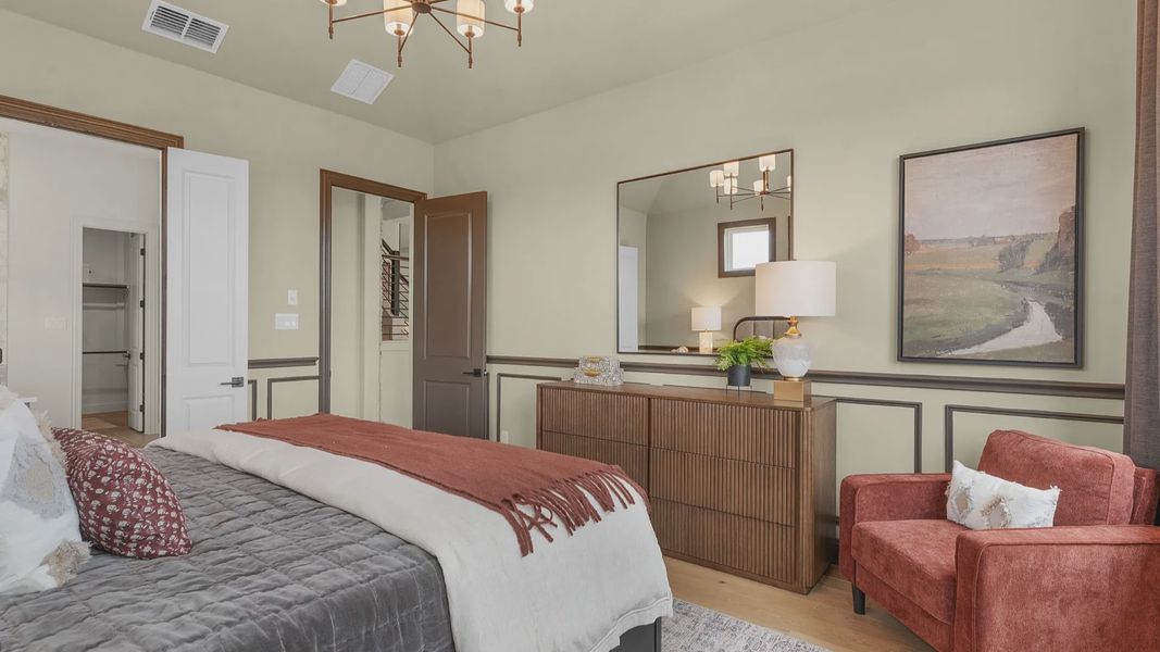 Owner’s suite with abundant natural light, woodwork details, and warm-toned flooring for a refined feel.