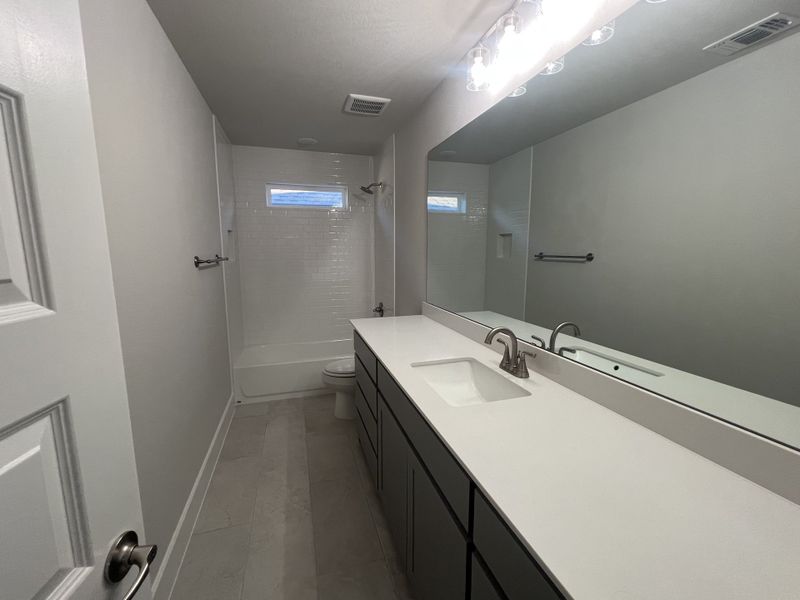 A sleek bathroom with a modern vanity, large mirror, and elegant finishes.