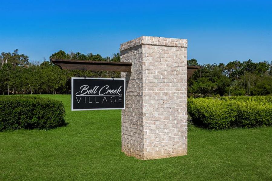 Entrance to the Bell Creek Townhomes community in Winnabow, NC, featuring signage and landscaping (Image 1).