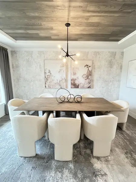 A modern dining room with a wooden table, plush chairs, abstract wall art, and a contemporary chandelier. A modern dining room with a wooden table, plush chairs, abstract wall art, and a contemporary chandelier.