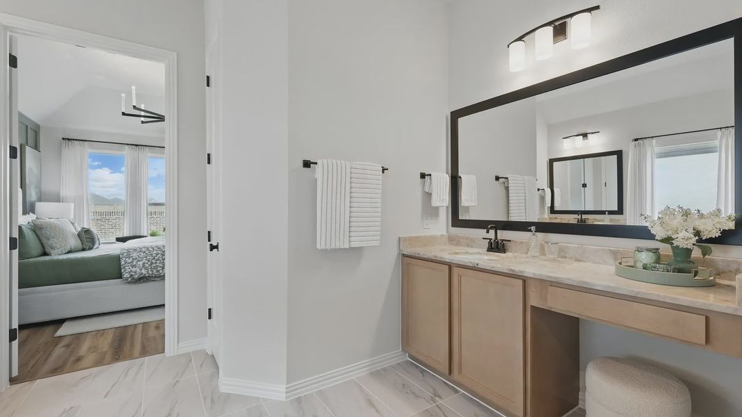 Marble countertops and expansive mirror enhance this sophisticated bathroom in Westridge.