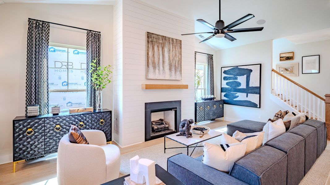 Gathering area with high ceilings, ceiling fan, and fireplace
