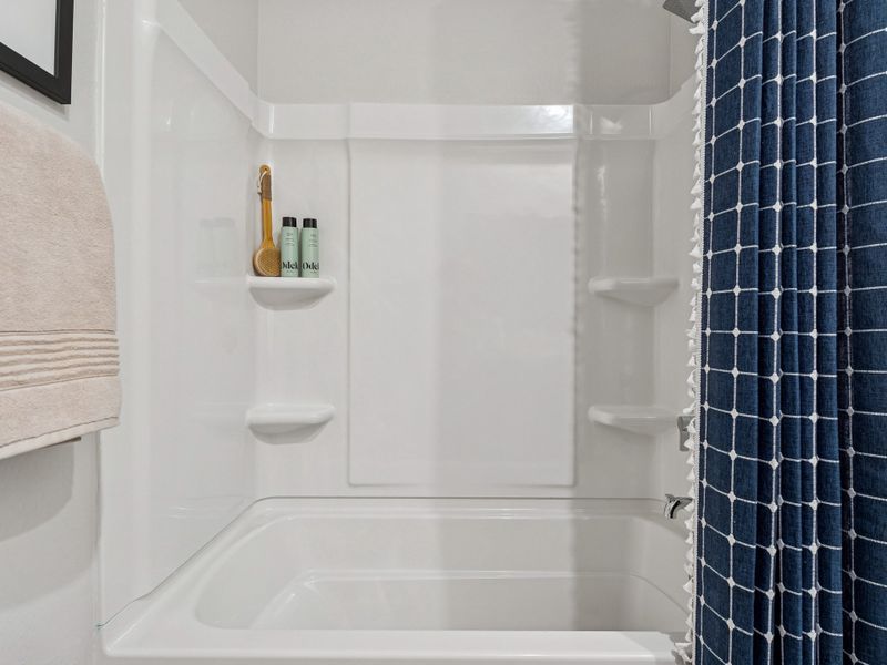 A bathroom with a shower and sink.