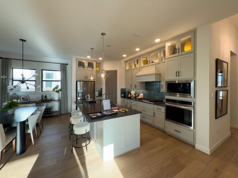 A modern kitchen with sleek cabinetry, stainless steel appliances, and a stylish dining area. A modern kitchen with sleek cabinetry, stainless steel appliances, and a stylish dining area.