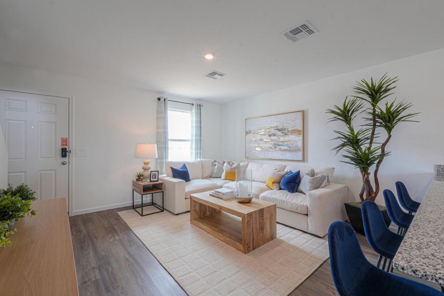 A living room with a white couch and a wood floor. A living room with a white couch and a wood floor.