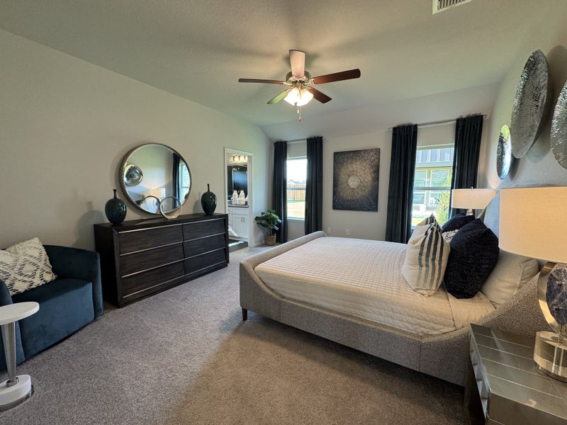 A cozy bedroom with a plush bed, elegant dresser, circular mirror, and stylish decor. A cozy bedroom with a plush bed, elegant dresser, circular mirror, and stylish decor.