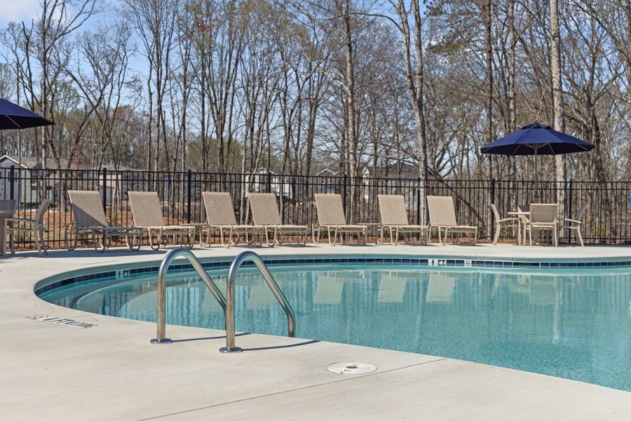 A pool with chairs around it. A pool with chairs around it.