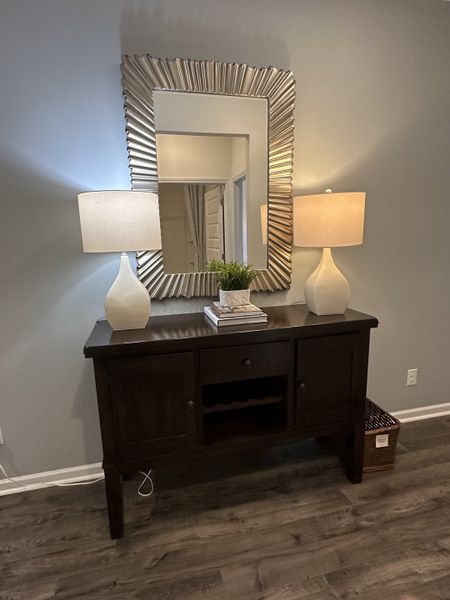 A sophisticated entryway with a dark wood console table, stylish lamps, and a decorative mirror for a welcoming touch.