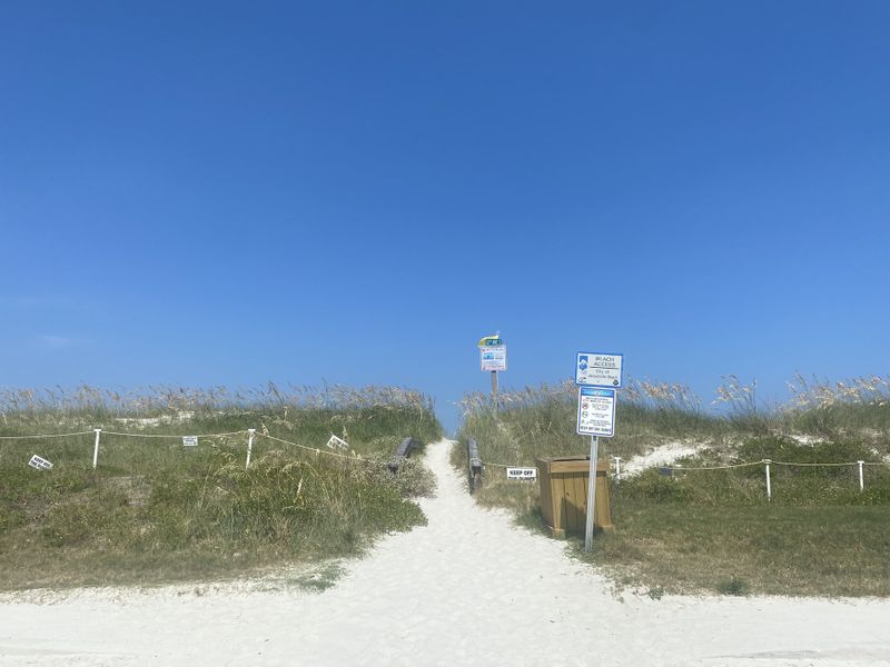 A scenic beach access path surrounded by dunes and signs in Pelican View Townhomes by A-Team Petroleum Construction (Jacksonville Beach, FL). A scenic beach access path surrounded by dunes and signs in Pelican View Townhomes by A-Team Petroleum Construction (Jacksonville Beach, FL).