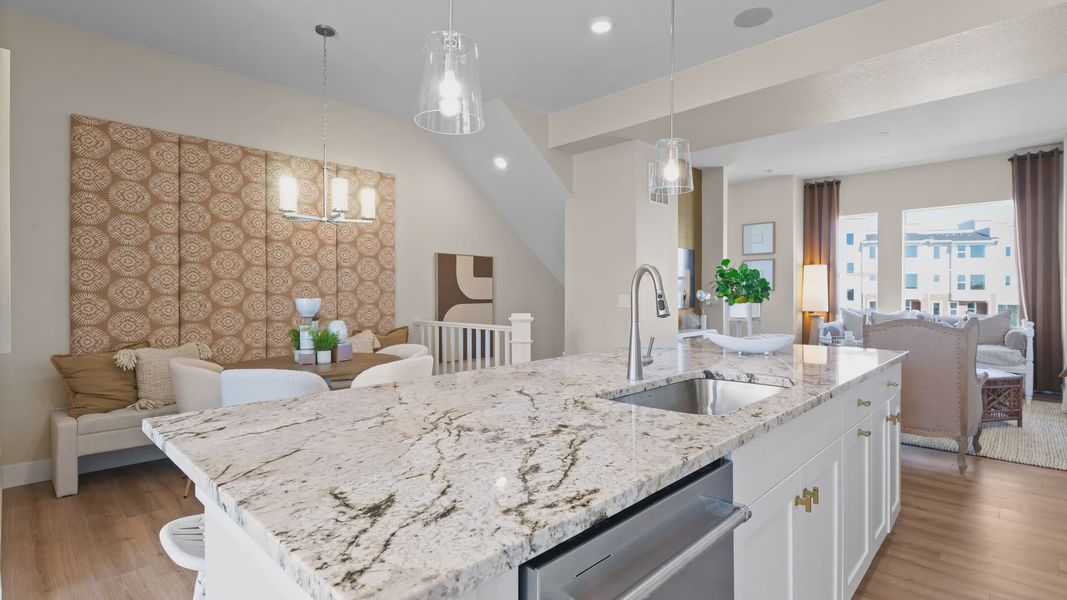 Polished granite island and stylish pendant lighting elevate this Dillon Pointe kitchen's elegance. Polished granite island and stylish pendant lighting elevate this Dillon Pointe kitchen's elegance.