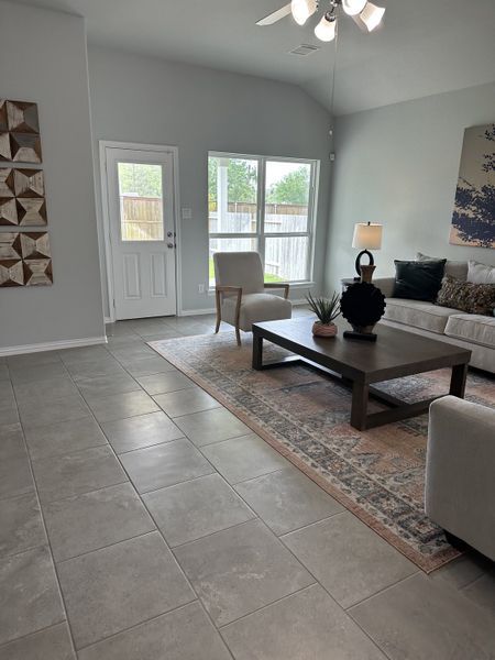 A spacious living room with tile flooring, modern decor, and large windows allowing natural light. A spacious living room with tile flooring, modern decor, and large windows allowing natural light.