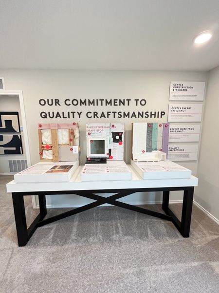 A quality-focused display table showcasing craftsmanship details, with various building materials and informative displays. A quality-focused display table showcasing craftsmanship details, with various building materials and informative displays.