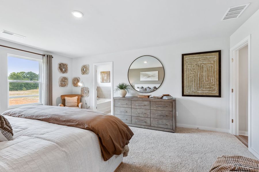 A bedroom with a bed and a mirror.