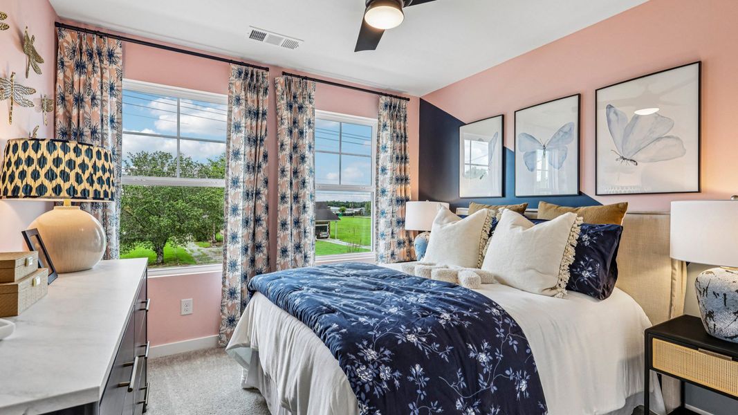 Secondary bedroom with ceiling fan, carpet, and windows