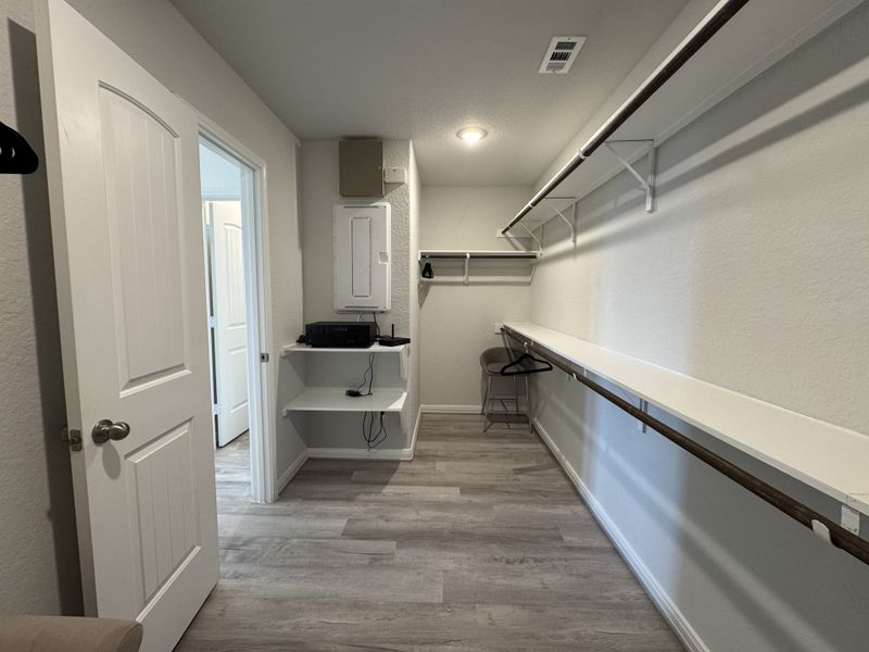 A spacious walk-in closet with sleek shelving, ample hanging space, and modern lighting.