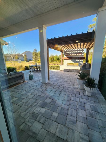A spacious patio with a pergola, modern outdoor furniture, and decorative plants, offering a serene backyard retreat. A spacious patio with a pergola, modern outdoor furniture, and decorative plants, offering a serene backyard retreat.