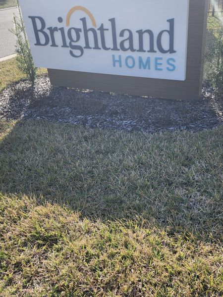 Signage for Brightland Homes in Panther Creek, Jacksonville, FL, set against a well-maintained grassy landscape.