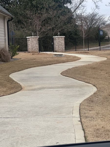 A charming landscaped pathway with brick and wrought iron gate in Cottages at Noble Village by Seed Capital Investments, LLC (Lilburn, GA). A charming landscaped pathway with brick and wrought iron gate in Cottages at Noble Village by Seed Capital Investments, LLC (Lilburn, GA).