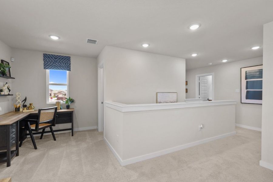 A large white room with a desk and chairs.