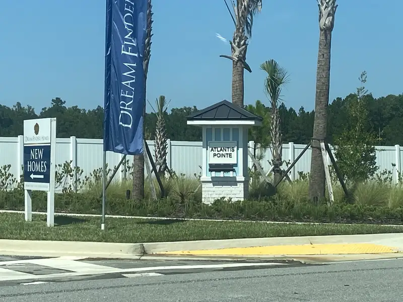 A welcoming entrance to Atlantis Pointe by Dream Finders Homes, surrounded by lush greenery in Middleburg, FL.