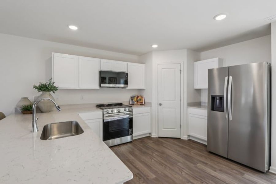 A kitchen with white cabinets.