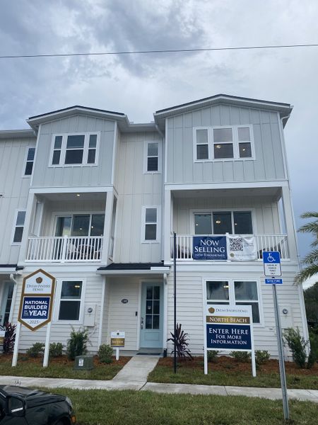 A modern white townhouse with clean lines and a welcoming entry in North Beach Townhomes by Dream Finders Homes (Jacksonville, FL). A modern white townhouse with clean lines and a welcoming entry in North Beach Townhomes by Dream Finders Homes (Jacksonville, FL).