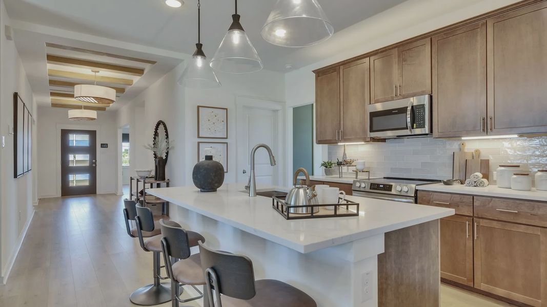 Sleek wooden cabinetry, modern appliances, and custom lighting highlight this luxurious Hunters Glen kitchen. Sleek wooden cabinetry, modern appliances, and custom lighting highlight this luxurious Hunters Glen kitchen.