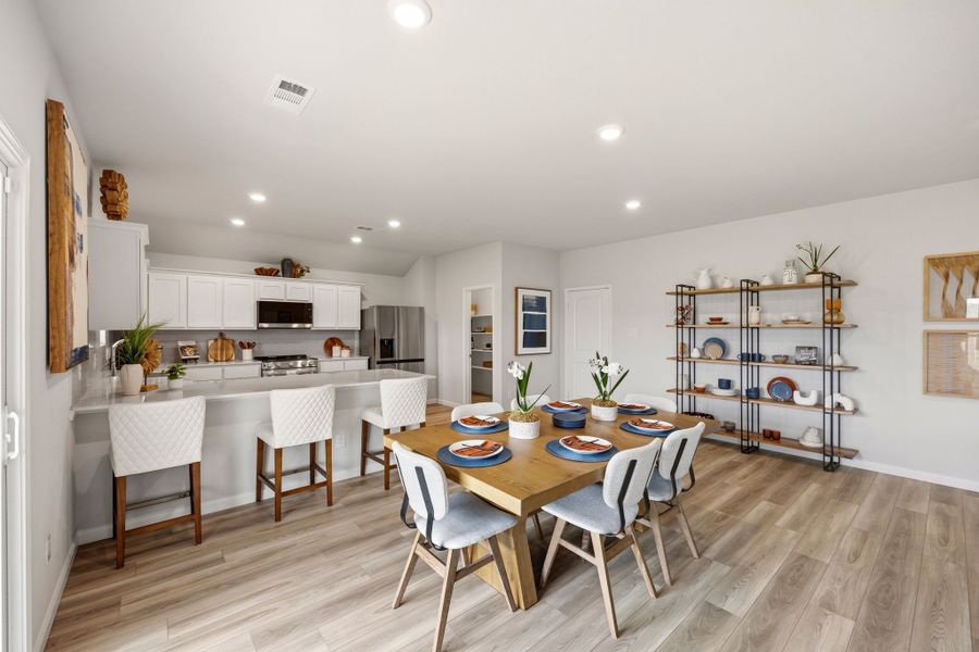 A kitchen with a dining table and chairs. A kitchen with a dining table and chairs.