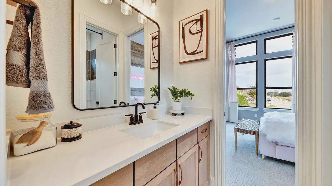 Luxurious wood cabinetry and sleek black fixtures enhance this Hawkes Landing bathroom's modern elegance.