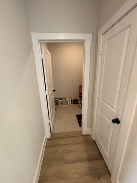 A functional space with tile flooring, leading to the laundry area with ample storage for household essentials. A functional space with tile flooring, leading to the laundry area with ample storage for household essentials.