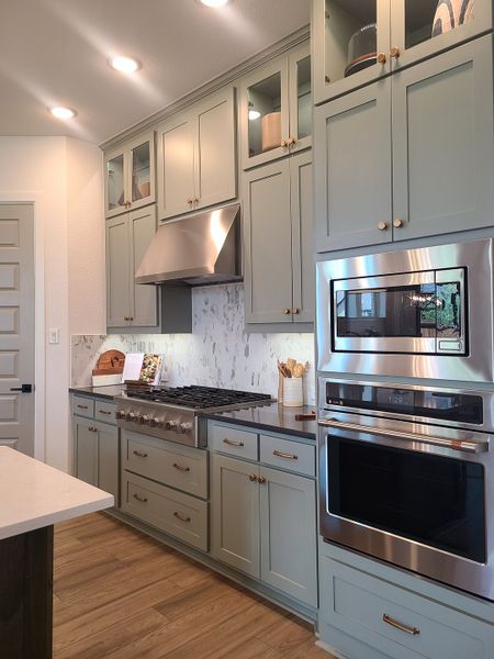 A modern kitchen with sleek cabinetry, stainless steel appliances, and elegant overhead lighting. A modern kitchen with sleek cabinetry, stainless steel appliances, and elegant overhead lighting.