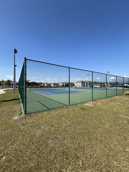 A spacious basketball court with professional markings and scenic surroundings in Avian Pointe Townhomes by D.R. Horton (Apopka, FL).