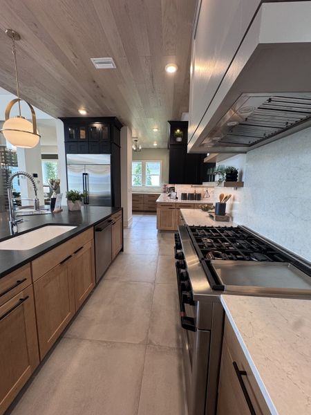 A modern kitchen with sleek wood cabinets, a spacious island, and stainless steel appliances.