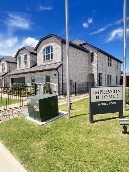 Charming white brick home with elegant dormers at Main Street Village by Impression Homes (Mansfield, TX). Charming white brick home with elegant dormers at Main Street Village by Impression Homes (Mansfield, TX).