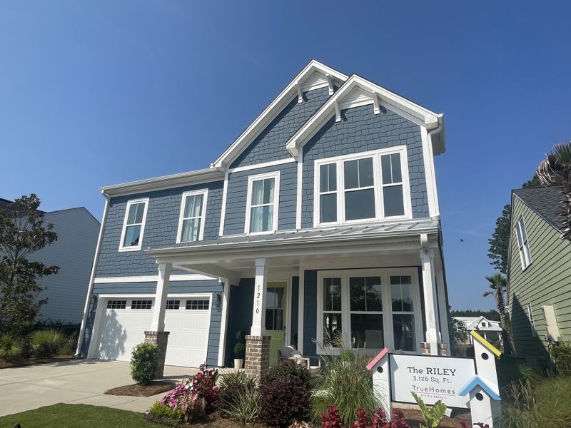 Charming blue two-story home with elegant white trim, in Homecoming by True Homes (Ravenel, SC).