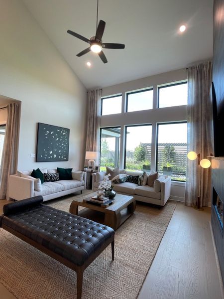 A contemporary living room with large windows, a plush rug, elegant sofas, and modern décor. A contemporary living room with large windows, a plush rug, elegant sofas, and modern décor.