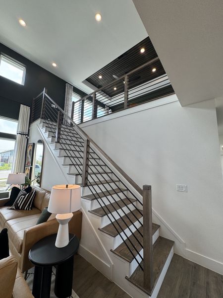 A modern interior featuring a sleek staircase with wooden steps, metal railings, and abundant natural light. A modern interior featuring a sleek staircase with wooden steps, metal railings, and abundant natural light.
